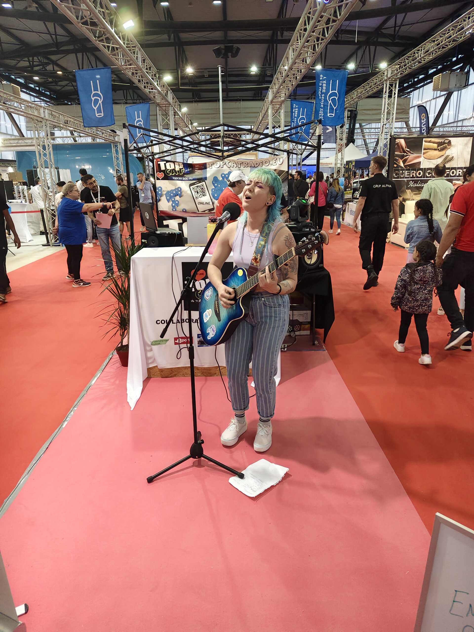 Photo of Emily Gray singing at the TopCat Radio stand at Expo Ebre 2025.